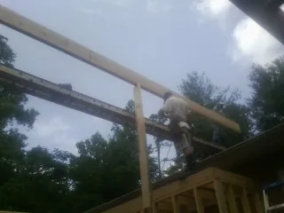 Carpenter setting a ridge beam over a new addition frame — Ice Dam Removal by Roofing Brothers in Norwood Young America