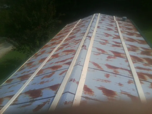 Rusted metal roof panels with new wood purlins before replacement — Storm Damage Roof Repair in Norwood Young America by Roofing Brothers