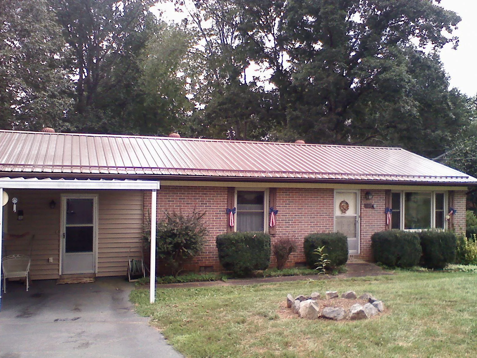Bronze metal roof and carport on a brick ranch home — Roof Repair work by our crew in Norwood Young America